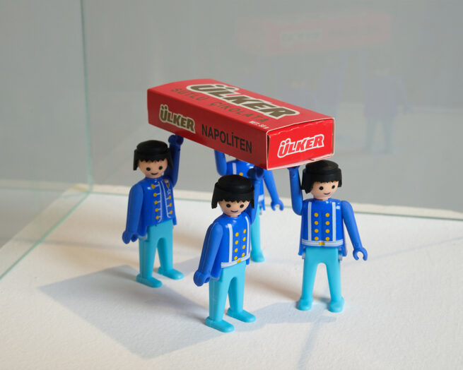four palymobil figures holding a box liek funeral