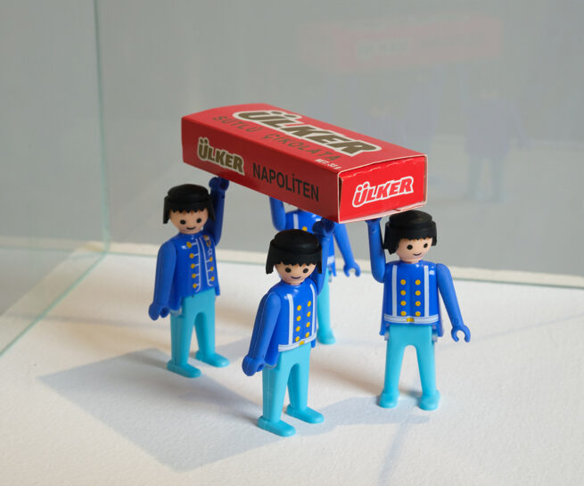 four palymobil figures holding a box liek funeral