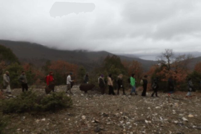 people walking on the mountain on a cloudy and rainy day
