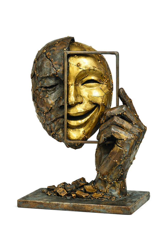 bronze sculpture of a face and a hand