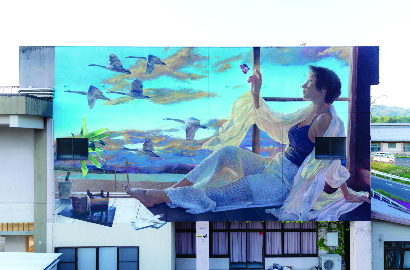 Graffiti showing a woman watching away and birds passing buy