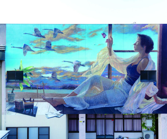 Graffiti showing a woman watching away and birds passing buy