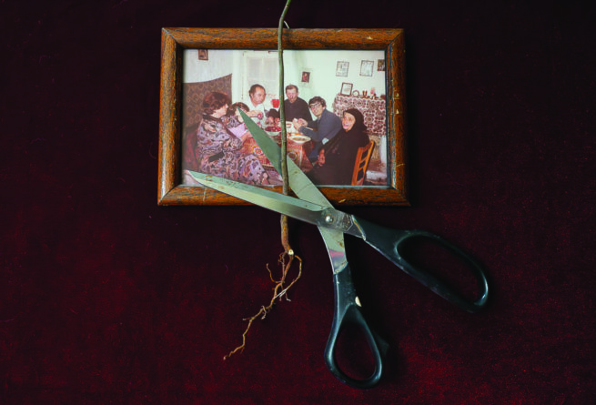 a scissors is cutting a cable in front of family photo