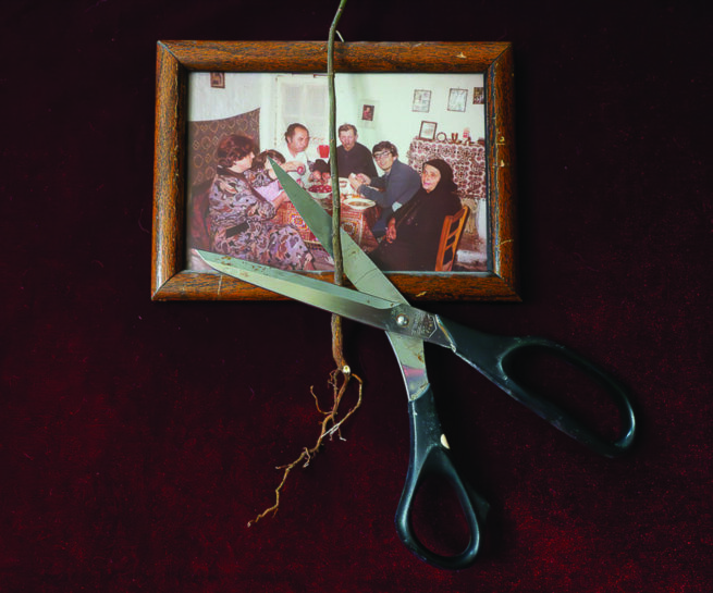 a scissors is cutting a cable in front of family photo