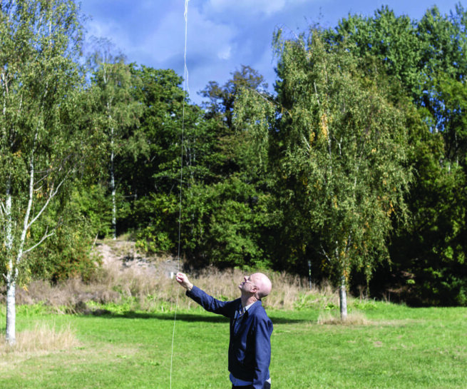 a person holding a grey ballon in the nature